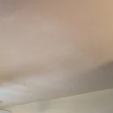 Close-up of a smoothly repaired ceiling with seamlessly matched knockdown texture