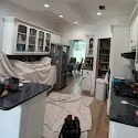 Kitchen with canvas drop cloths covering counters and floors for dust containment