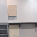 Drywall access patch above cabinets being taped after a plumbing repipe